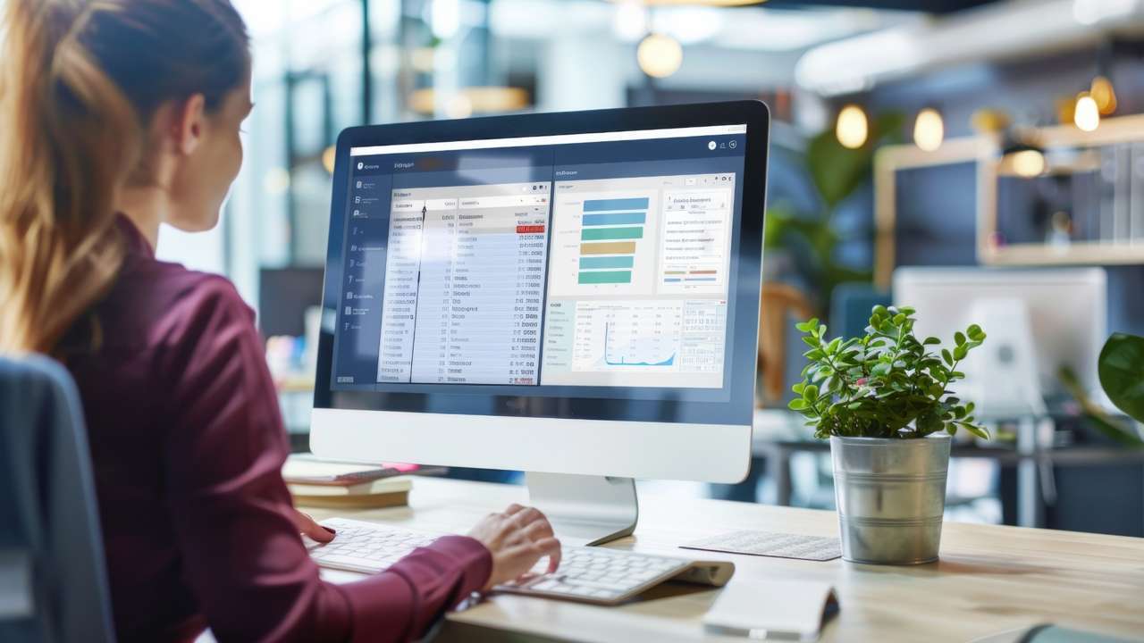 A compliance officer reviews workforce visa data and dashboards on a computer screen.